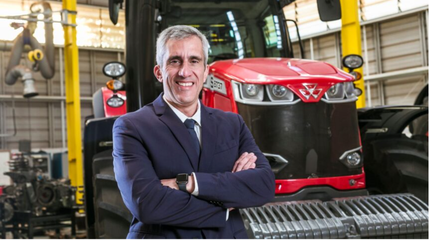Executivo apresentando implemento agrícola em fábrica